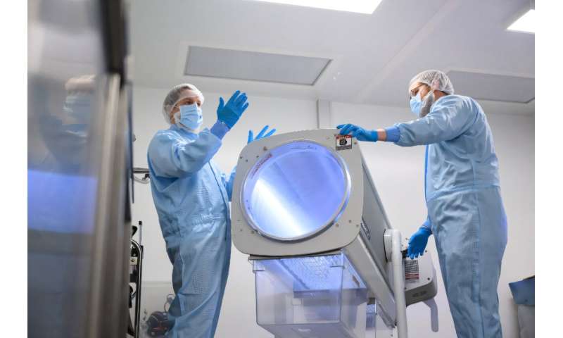Staff show a specialized device for processing the raw cannabis flowers